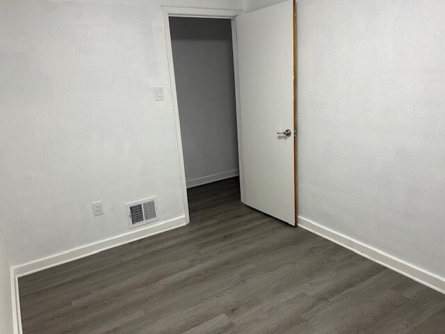 empty room with dark wood-type flooring