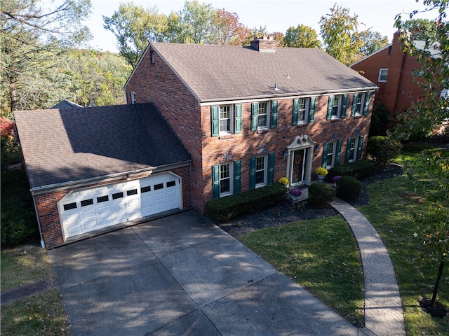 colonial home with a front lawn and a garage