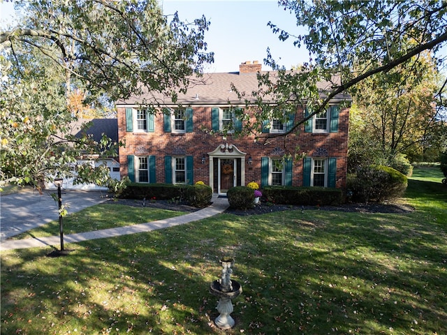 colonial inspired home featuring a front lawn