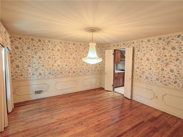 unfurnished dining area with ornamental molding and hardwood / wood-style flooring