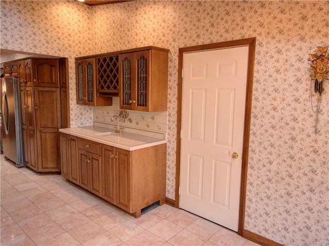 kitchen featuring light tile patterned floors, sink, and stainless steel fridge