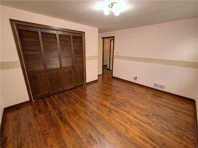 unfurnished bedroom featuring a closet and dark hardwood / wood-style floors