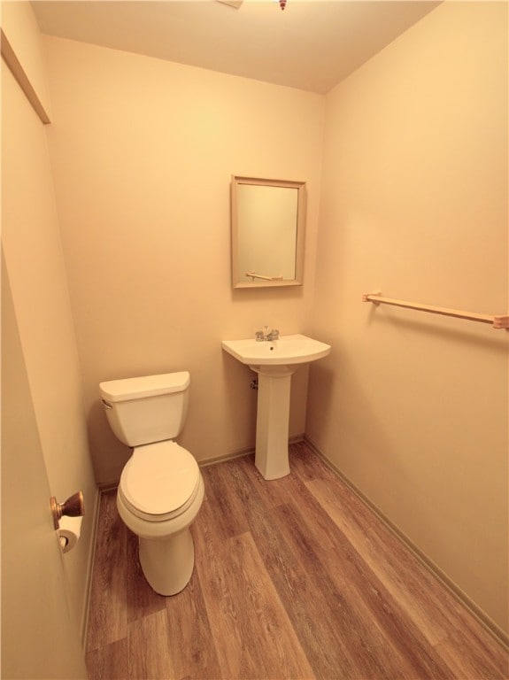 bathroom with toilet and wood-type flooring