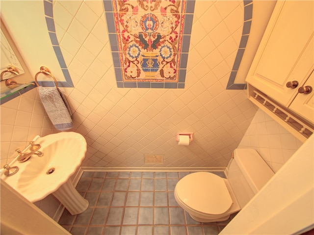 bathroom with tile walls, toilet, and tile patterned flooring