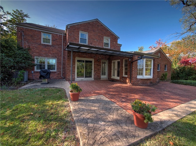 rear view of property with a yard and a patio area