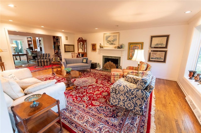 living room featuring crown molding, plenty of natural light, and hardwood / wood-style floors