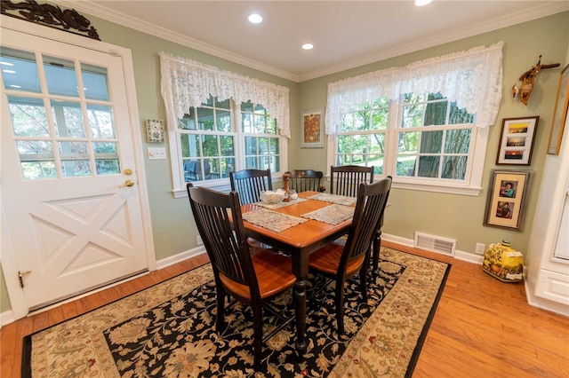 dining area featuring ornamental molding, light hardwood / wood-style flooring, and plenty of natural light