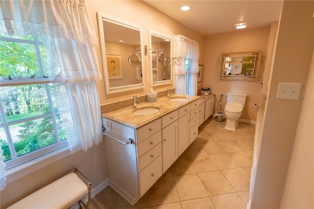 bathroom with toilet, vanity, and tile patterned floors