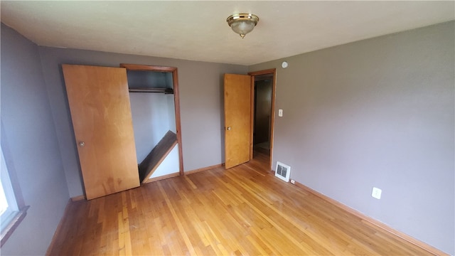 unfurnished bedroom featuring light hardwood / wood-style flooring and a closet