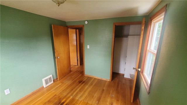 unfurnished bedroom featuring light hardwood / wood-style floors and a closet