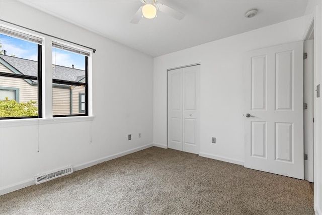 unfurnished bedroom with a closet, carpet floors, and ceiling fan