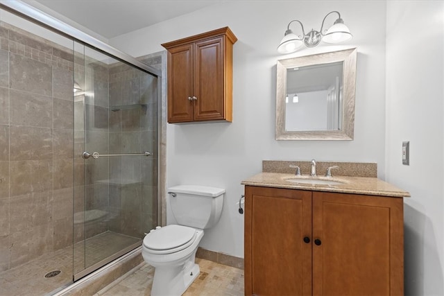 bathroom featuring vanity, toilet, and a shower with door