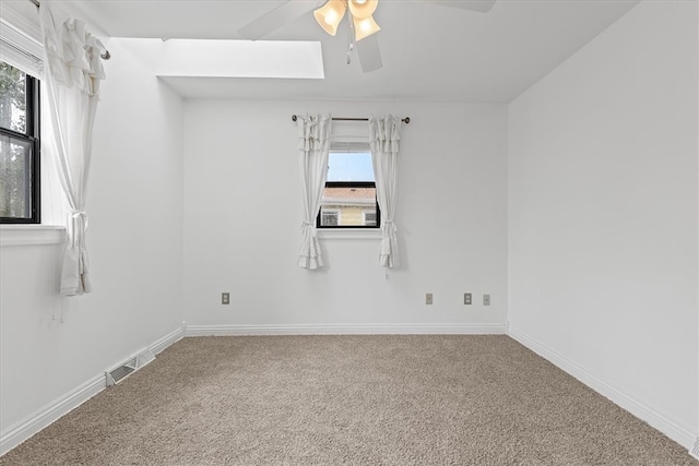 empty room featuring ceiling fan, cooling unit, carpet floors, and plenty of natural light