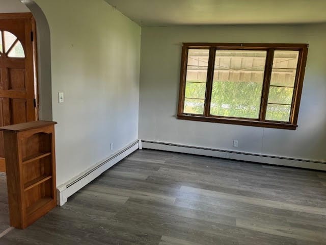 foyer entrance with a baseboard radiator, dark wood-type flooring, and plenty of natural light