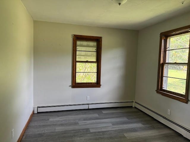 empty room with a baseboard radiator and dark hardwood / wood-style flooring