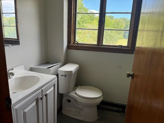 bathroom with vanity, toilet, and a baseboard heating unit