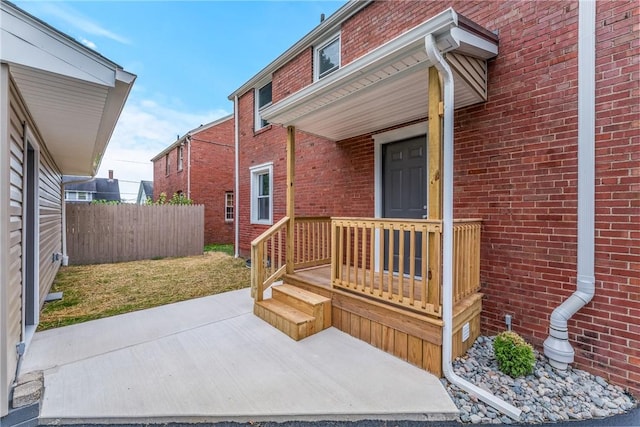 entrance to property featuring a lawn and a patio