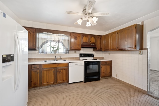 kitchen with white appliances, ceiling fan, light carpet, and sink