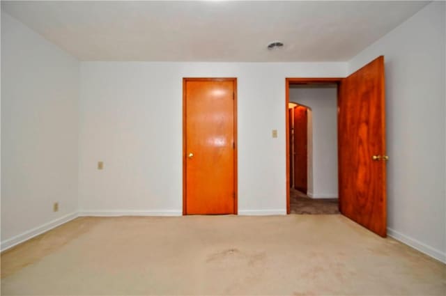 unfurnished bedroom with light carpet and baseboards