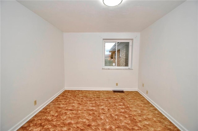 spare room with baseboards, visible vents, and carpet flooring