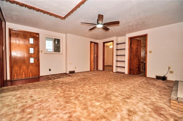 unfurnished living room featuring carpet floors, ceiling fan, and visible vents