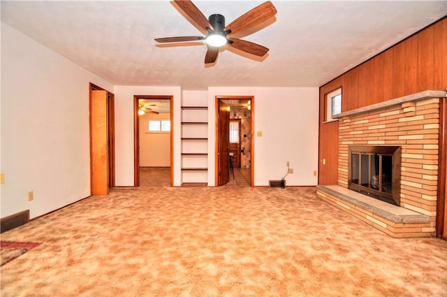 unfurnished living room with ceiling fan, carpet, a fireplace, and visible vents