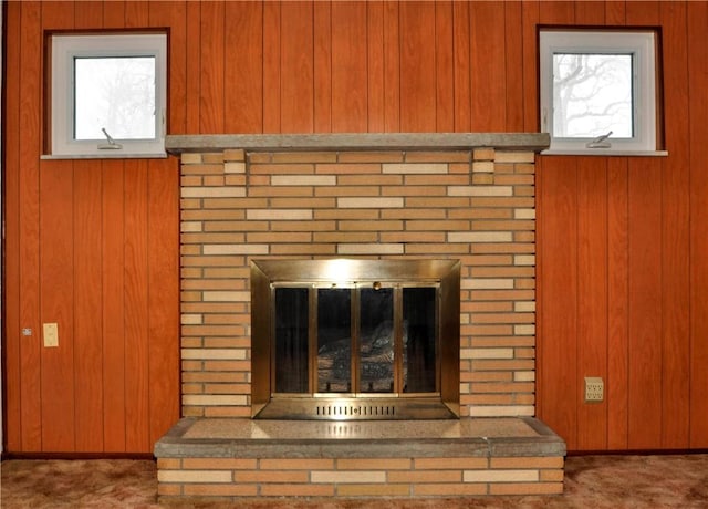 room details featuring wood walls and a brick fireplace