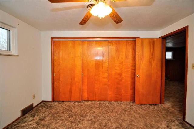 unfurnished bedroom with a closet, visible vents, carpet flooring, ceiling fan, and baseboards