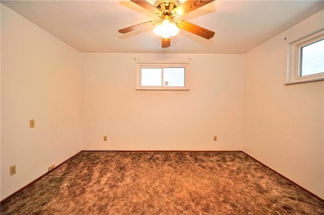 spare room with carpet floors, a wealth of natural light, and baseboards