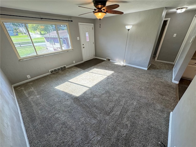 interior space featuring dark carpet and ceiling fan