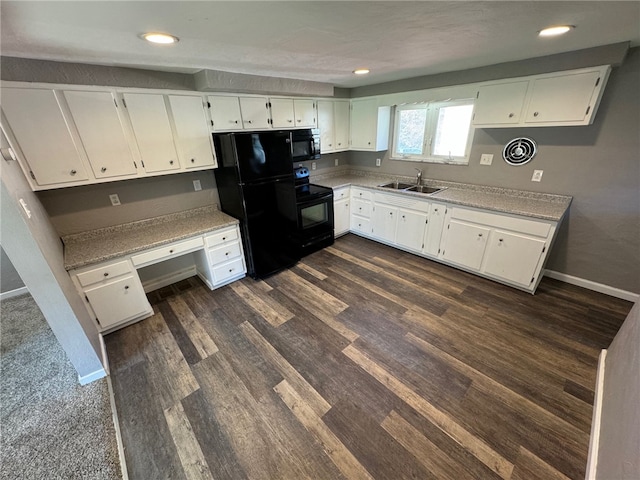 kitchen featuring white cabinets, black appliances, sink, and built in desk