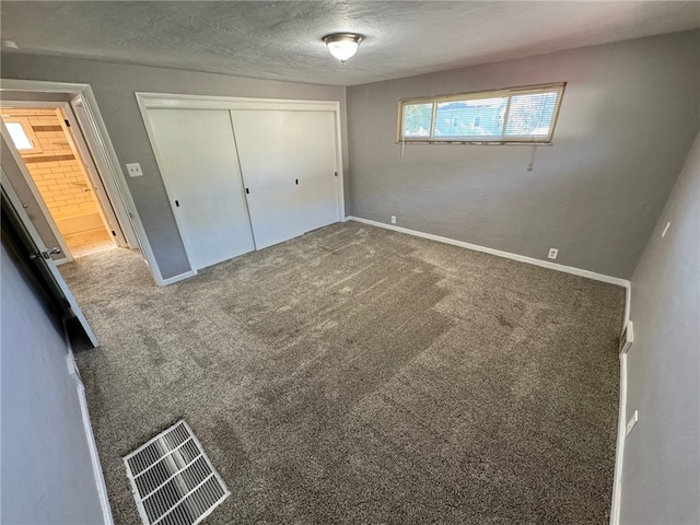 unfurnished bedroom featuring a closet, a textured ceiling, and carpet