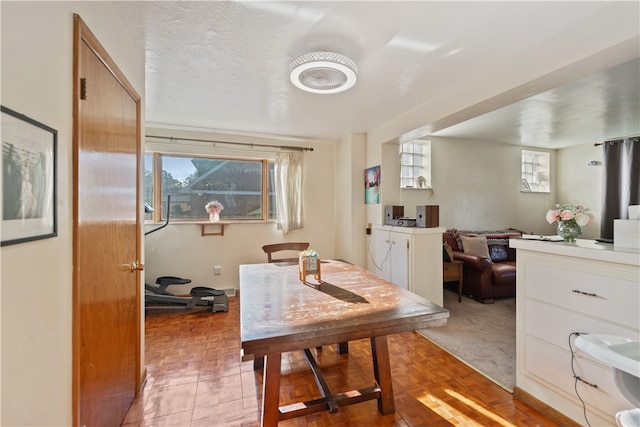 carpeted dining space with a textured ceiling