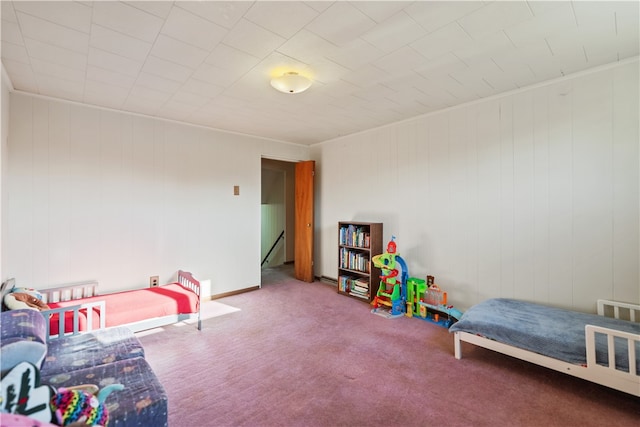 bedroom featuring carpet floors and wooden walls