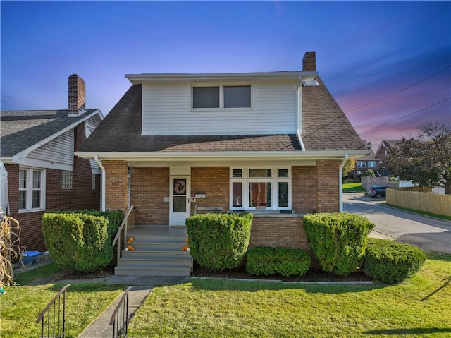 view of front of property featuring a lawn and a porch