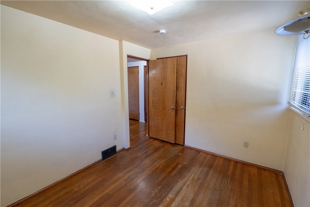 unfurnished room with dark wood-type flooring