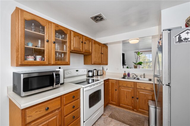 kitchen with white range with electric stovetop, sink, and fridge