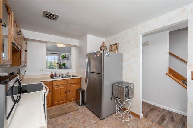 kitchen featuring sink, appliances with stainless steel finishes, and light hardwood / wood-style floors