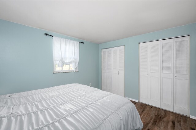 bedroom featuring two closets and dark hardwood / wood-style flooring