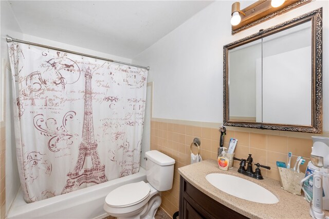 full bathroom with vanity, toilet, shower / bathtub combination with curtain, and tile walls