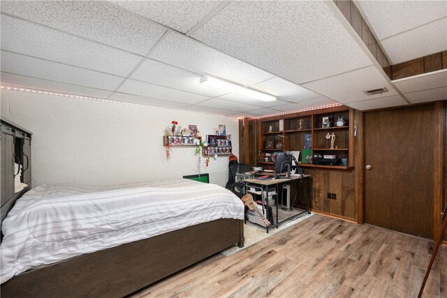 bedroom with hardwood / wood-style flooring and a drop ceiling