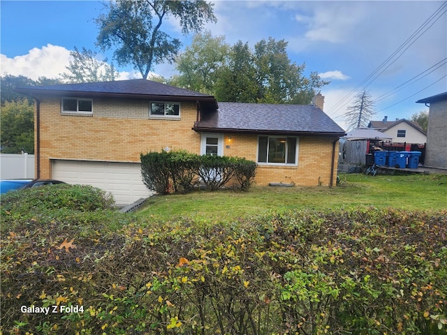 split level home featuring a front yard and a garage