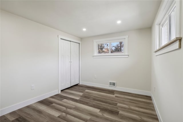 unfurnished bedroom featuring a closet and dark hardwood / wood-style floors