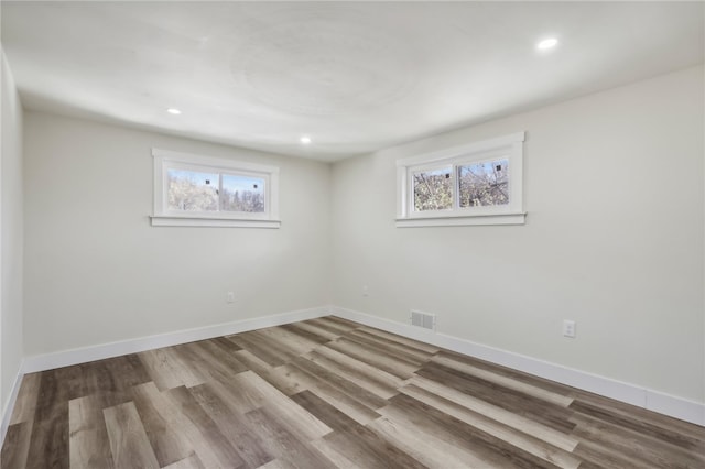 spare room featuring plenty of natural light and light hardwood / wood-style floors