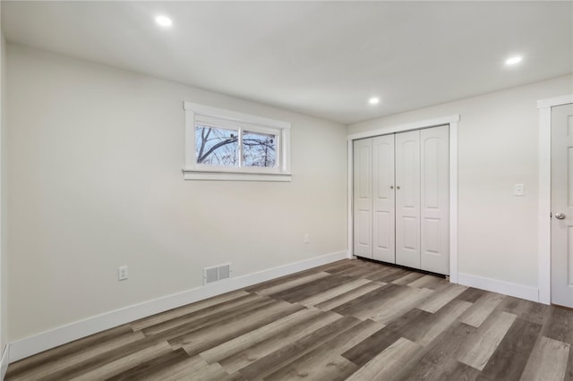 unfurnished bedroom featuring dark hardwood / wood-style floors and a closet