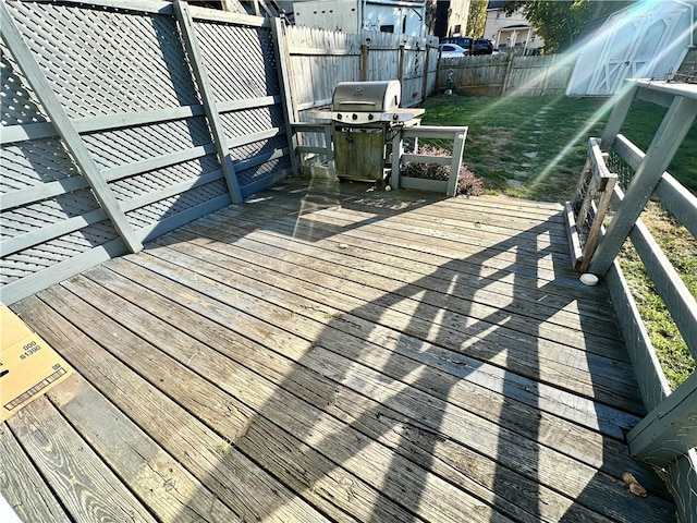 deck with a grill and a lawn