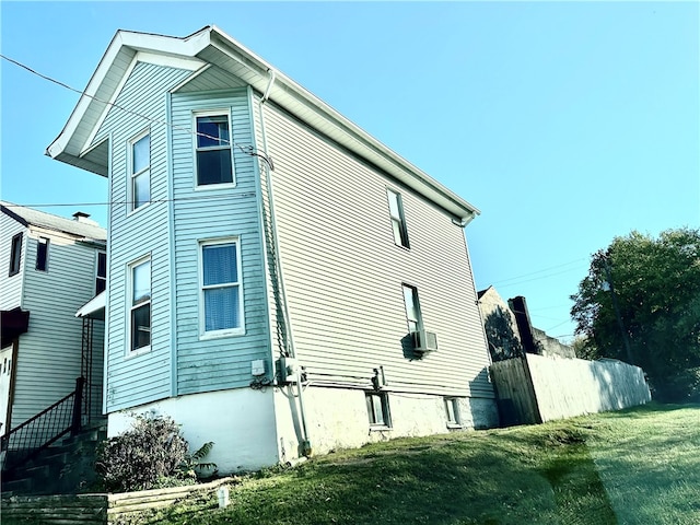 view of side of property with cooling unit and a lawn