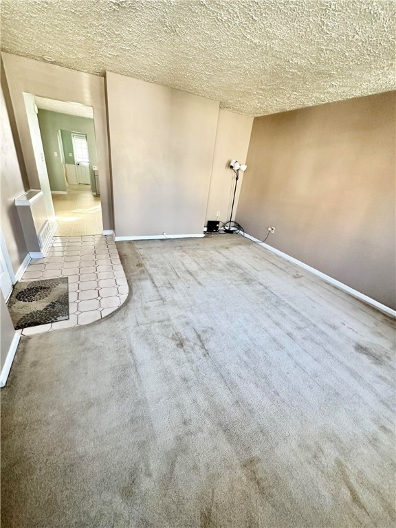 empty room featuring a textured ceiling and carpet flooring