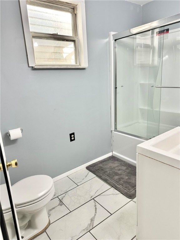 full bathroom featuring toilet, combined bath / shower with glass door, washer / clothes dryer, and vanity