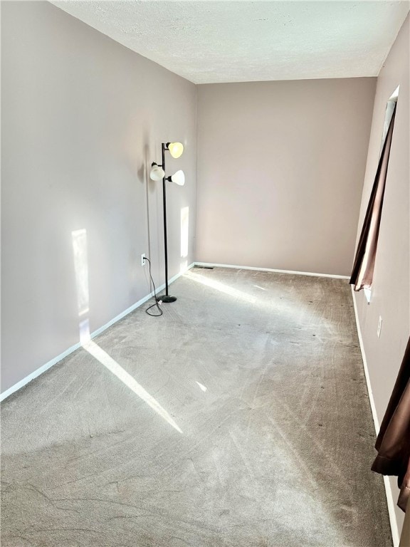 spare room with a textured ceiling and carpet flooring